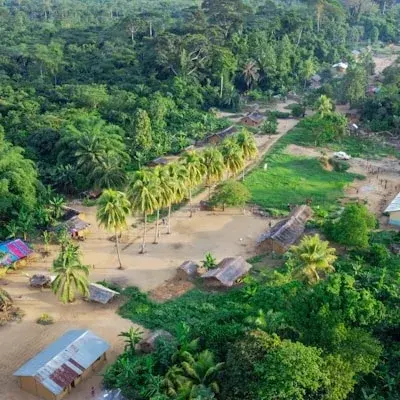 Aerial view of a village clearing in dense rainforest